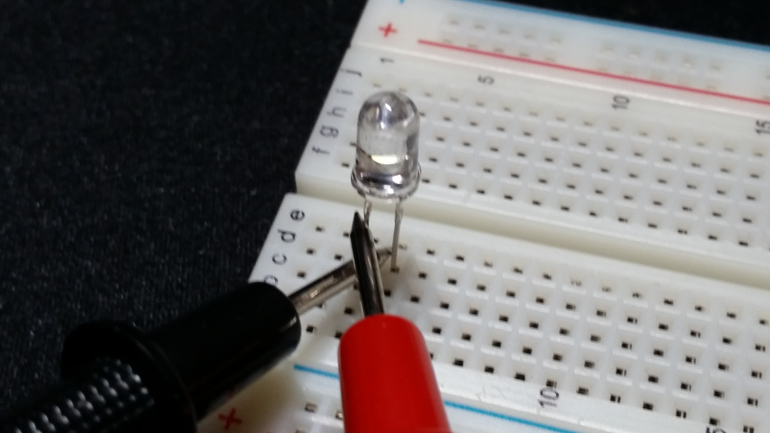 With the probes on opposite leads, the LED doesn't light up